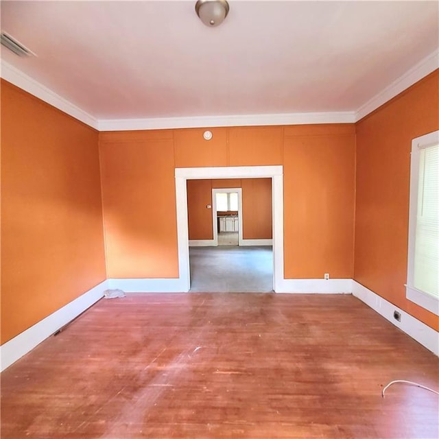 spare room featuring hardwood / wood-style flooring, a healthy amount of sunlight, and ornamental molding