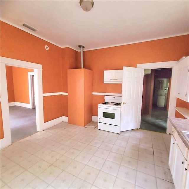 kitchen with white range oven, white cabinetry, and crown molding