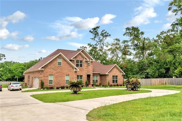 traditional home featuring driveway, brick siding, a front lawn, and fence