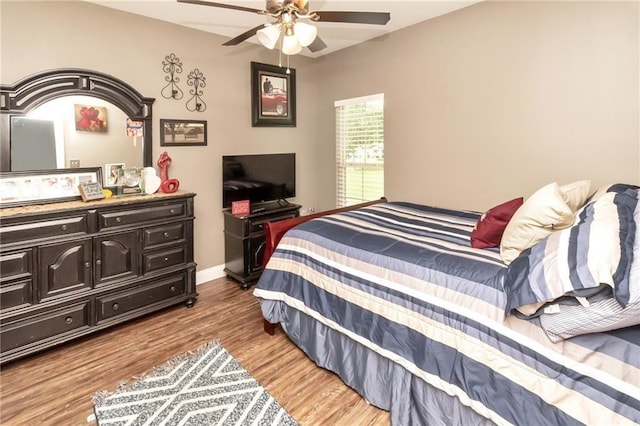 bedroom featuring light wood-type flooring, a ceiling fan, and baseboards