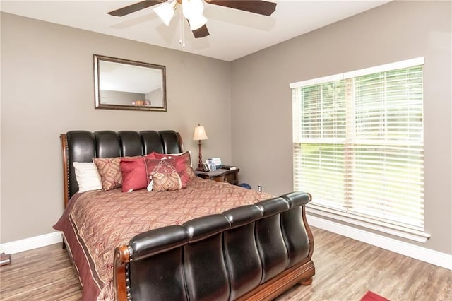 bedroom featuring a ceiling fan, baseboards, and wood finished floors