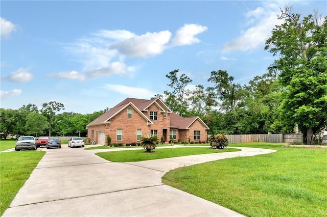 traditional-style house with driveway, fence, and a front yard