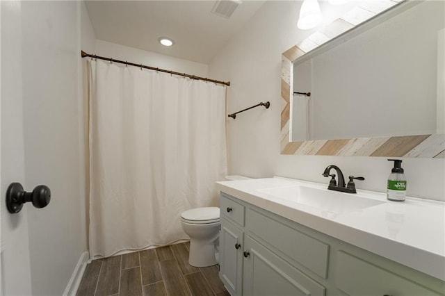 bathroom with wood-type flooring, vanity, and toilet