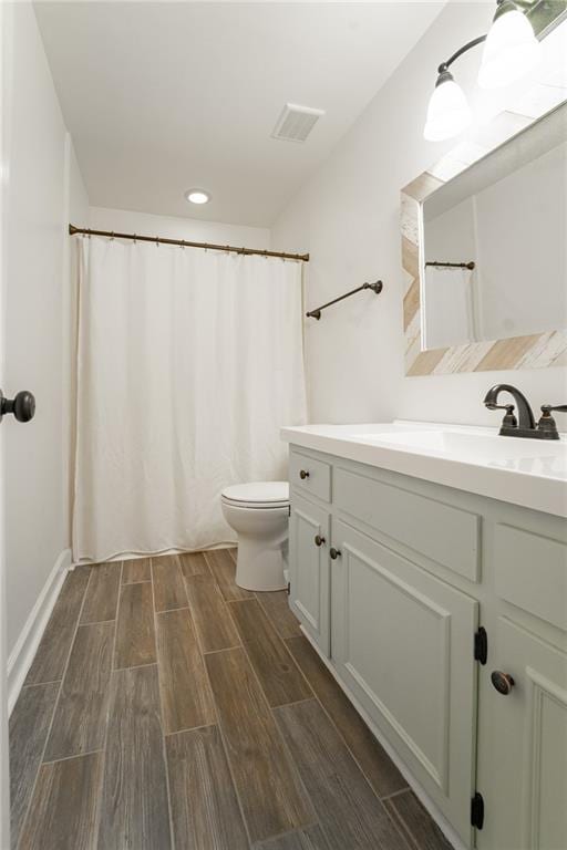 bathroom featuring vanity, wood-type flooring, and toilet