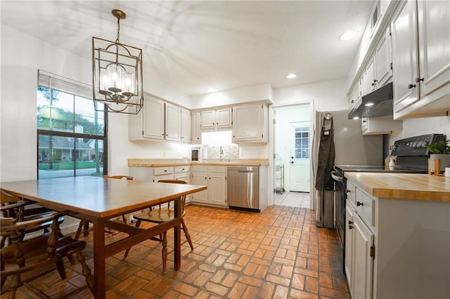 kitchen featuring pendant lighting, dishwasher, electric range, a notable chandelier, and white cabinetry