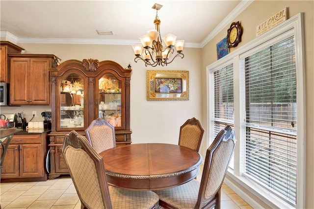 tiled dining room featuring an inviting chandelier and ornamental molding