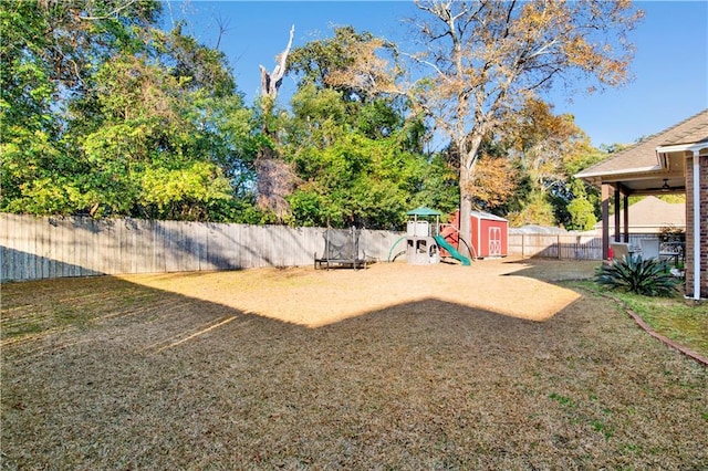 view of yard featuring a playground and a shed