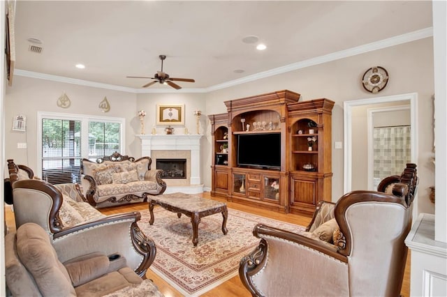 living room with crown molding, light hardwood / wood-style flooring, and ceiling fan