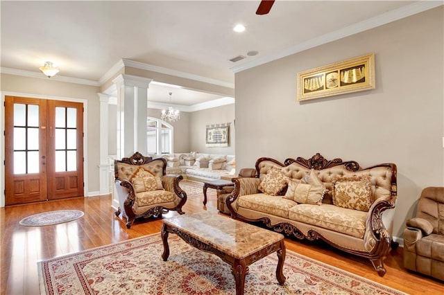 living room featuring ornate columns, ornamental molding, and light hardwood / wood-style floors