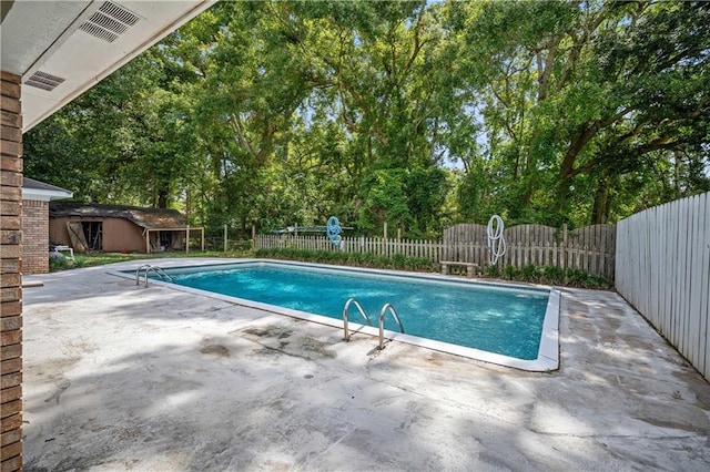8500 Cindy Lou Dr, Theodore, AL 36582 - view of swimming pool featuring a patio area, a fenced backyard, view of wooded area, and an outdoor structure