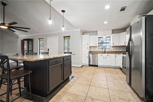 8500 Cindy Lou Dr, Theodore, AL 36582 - kitchen featuring stainless steel appliances, lofted ceiling, ceiling fan, a textured ceiling, and white cabinetry