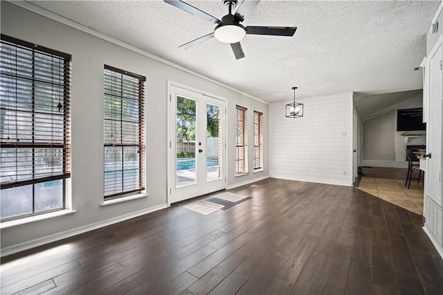 8500 Cindy Lou Dr, Theodore, AL 36582 - empty room with a textured ceiling, a ceiling fan, dark wood finished floors, a fireplace, and french doors