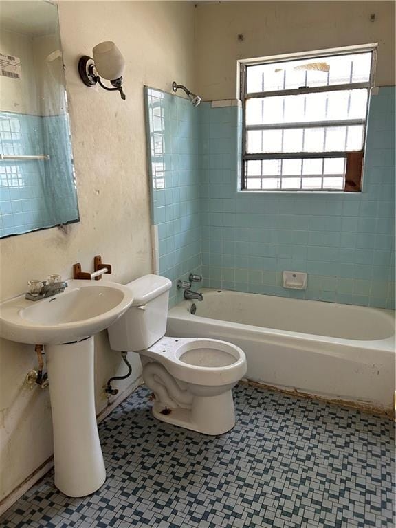 bathroom with tiled shower / bath combo and toilet