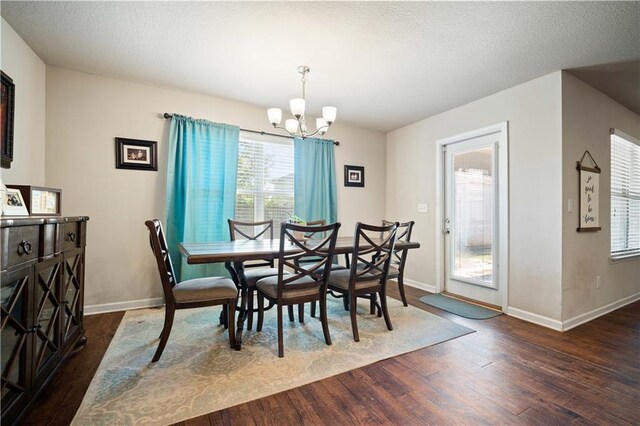 dining space with a chandelier, dark hardwood / wood-style floors, and a textured ceiling