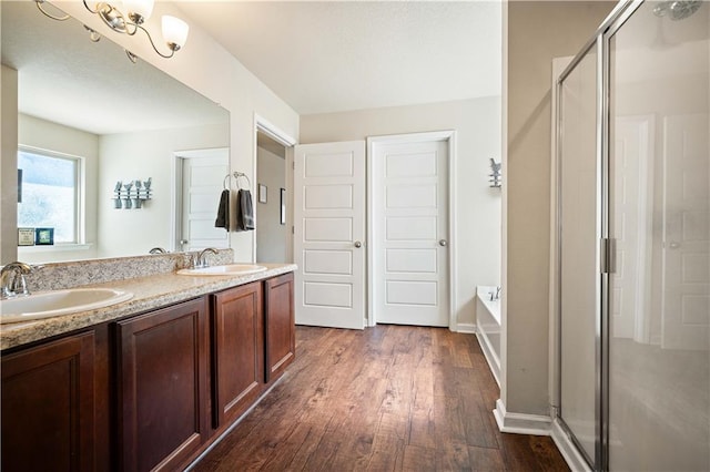 bathroom with wood-type flooring, vanity, and independent shower and bath