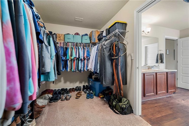 spacious closet with sink and dark hardwood / wood-style floors