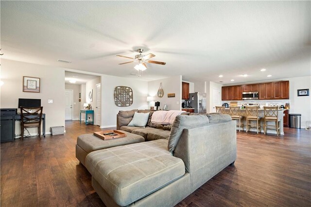 living room featuring ceiling fan and dark wood-type flooring