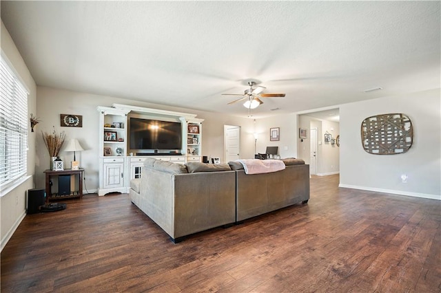 living room with dark wood-type flooring and ceiling fan