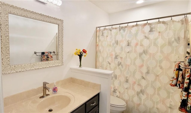 bathroom with toilet, vanity, and curtained shower