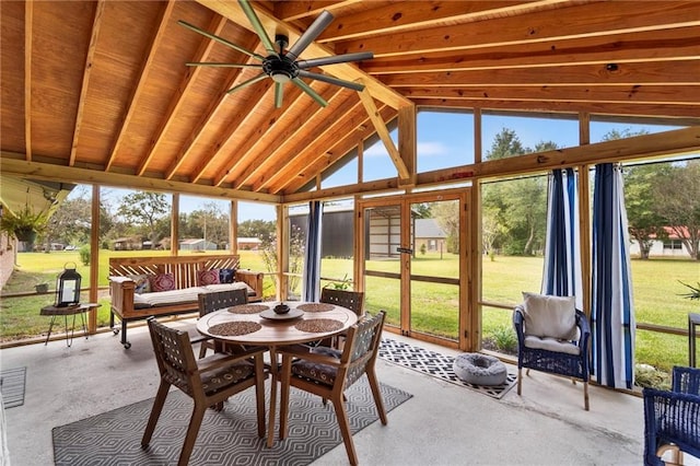 sunroom / solarium with lofted ceiling with beams, plenty of natural light, and ceiling fan