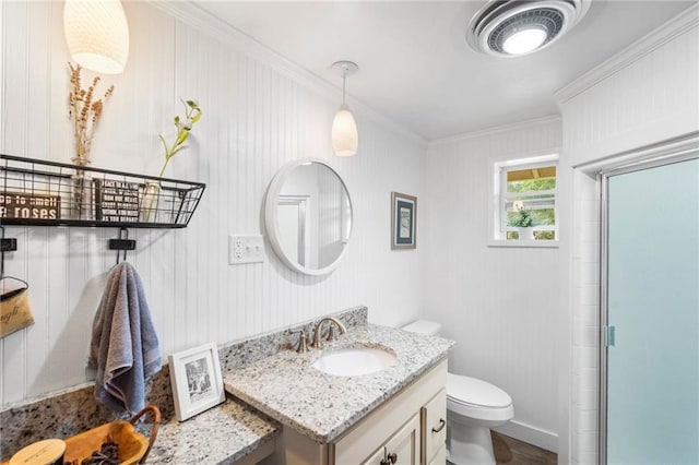 bathroom with toilet, crown molding, walk in shower, and vanity