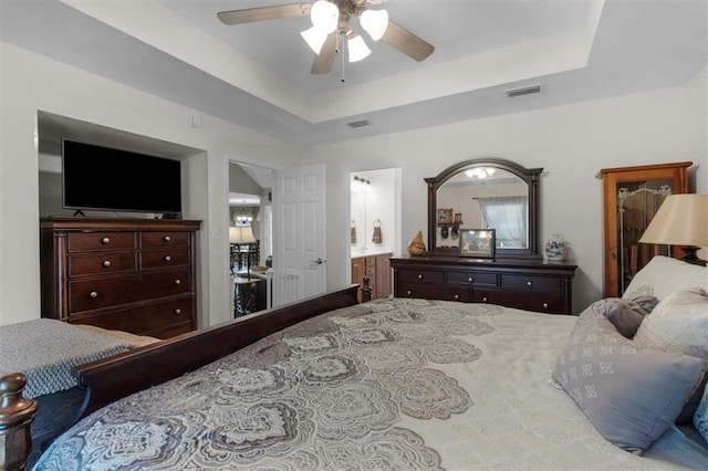 bedroom featuring a ceiling fan, a tray ceiling, and visible vents