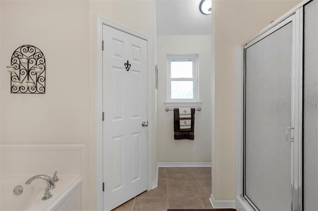 full bath featuring baseboards, a stall shower, a bathing tub, and tile patterned floors