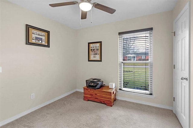 interior space featuring light carpet, ceiling fan, and baseboards