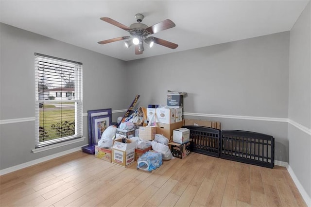 interior space featuring light wood-type flooring, a ceiling fan, and baseboards