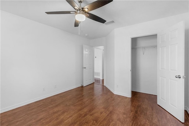 unfurnished bedroom with dark hardwood / wood-style flooring, a closet, and ceiling fan