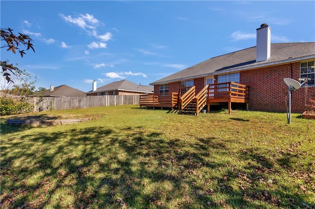 back of house with a wooden deck and a lawn