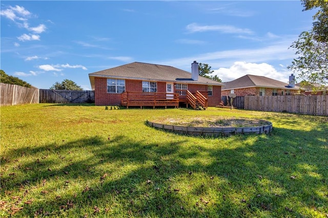 back of property featuring a yard and a wooden deck