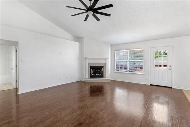 unfurnished living room featuring lofted ceiling, a textured ceiling, hardwood / wood-style flooring, and ceiling fan