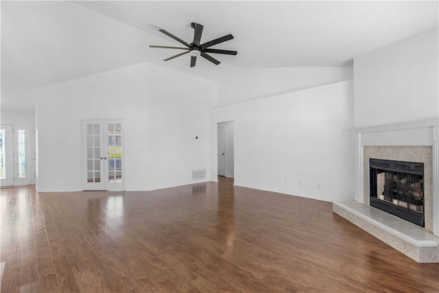 unfurnished living room with french doors, a high end fireplace, vaulted ceiling, dark hardwood / wood-style flooring, and ceiling fan