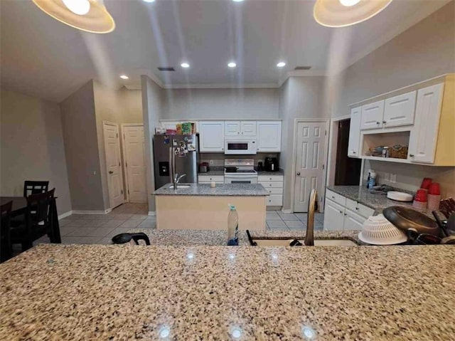 kitchen featuring white cabinetry, a kitchen island, light tile patterned floors, and white appliances