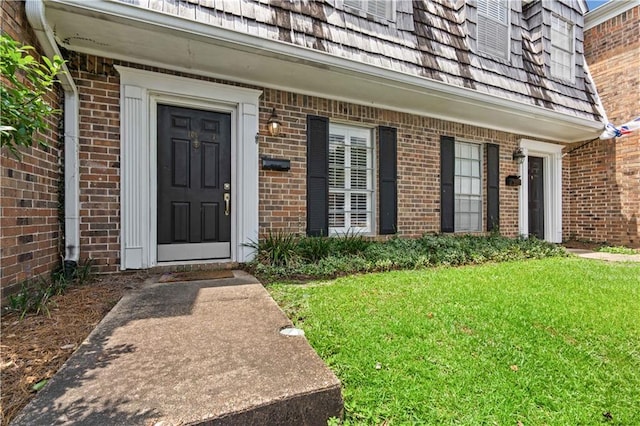 property entrance with a lawn