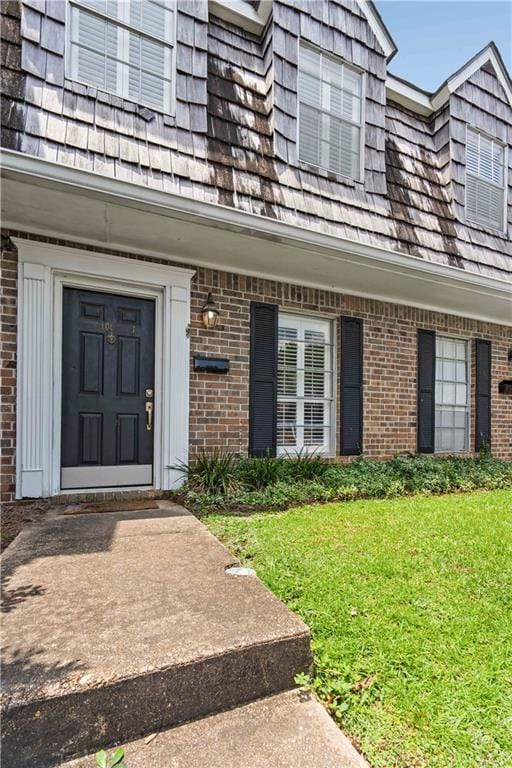 doorway to property featuring a lawn