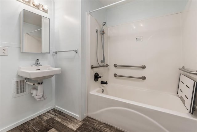 bathroom featuring hardwood / wood-style flooring and bathing tub / shower combination