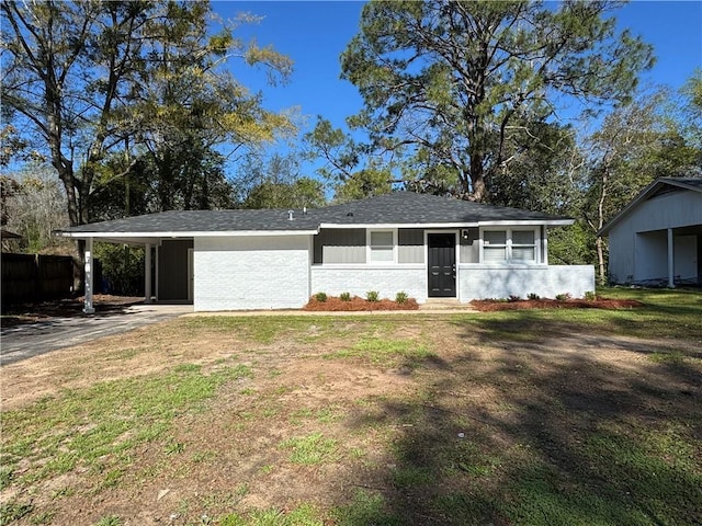 ranch-style home with an attached carport, driveway, and a front lawn