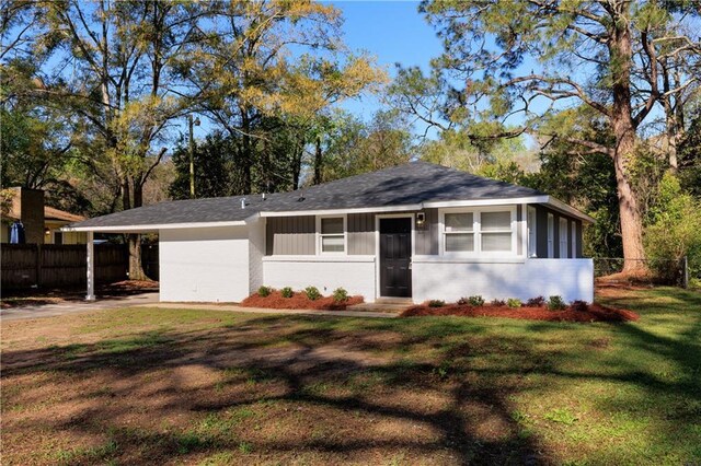 ranch-style home with fence, a front yard, and a carport