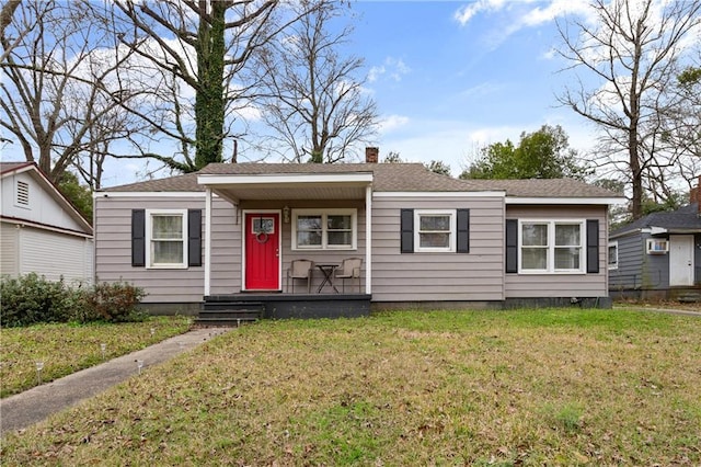 view of front of property with roof with shingles, a front lawn, and a chimney