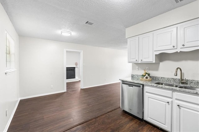 kitchen featuring white cabinets, dark wood-style floors, dishwasher, visible vents, and a sink