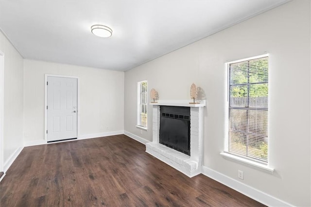 unfurnished living room featuring baseboards, a fireplace, and dark wood finished floors