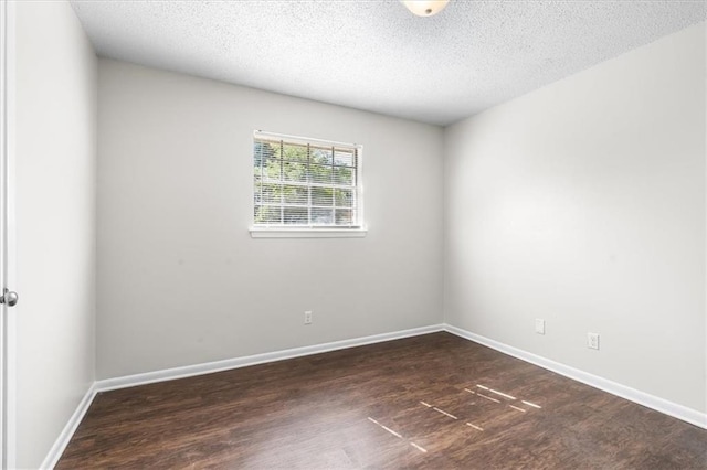 unfurnished room featuring baseboards, wood finished floors, and a textured ceiling