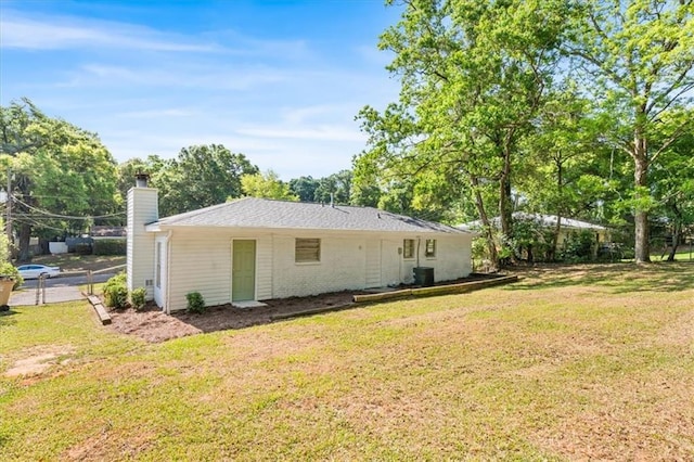 rear view of property with fence, a lawn, and a chimney