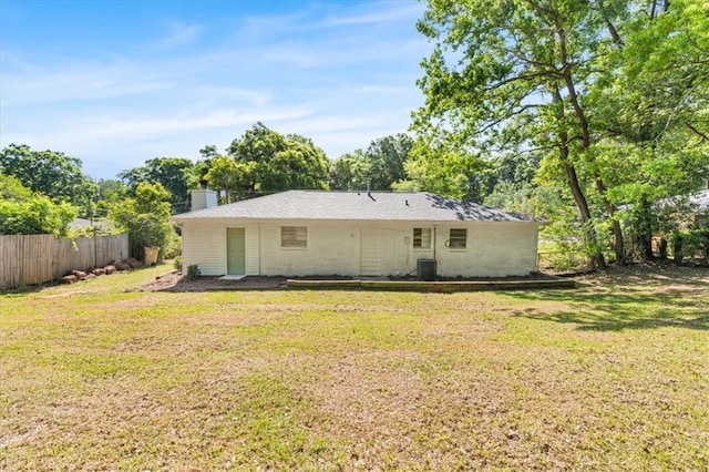 rear view of house featuring fence, a yard, and cooling unit