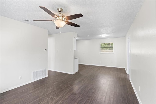 empty room featuring dark wood finished floors, a textured ceiling, visible vents, and a ceiling fan