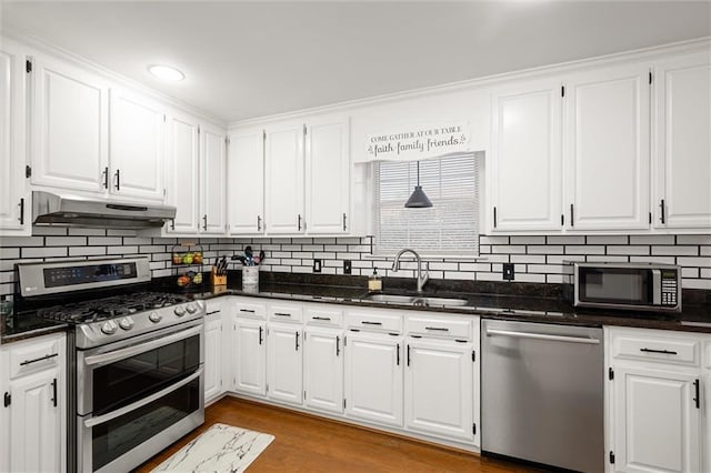 kitchen featuring sink, tasteful backsplash, appliances with stainless steel finishes, white cabinets, and light wood-type flooring