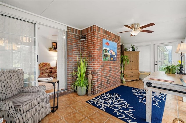 interior space with ceiling fan and brick wall