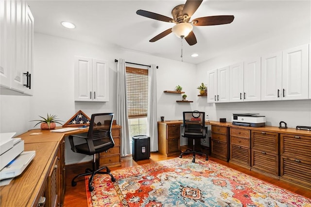 office with ceiling fan, built in desk, and light wood-type flooring